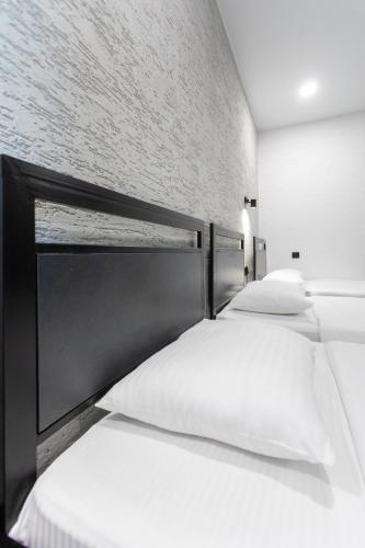 two beds with white pillows in a room at Hotel West Way in Kutaisi