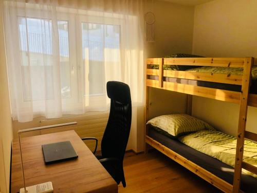 Zimmer mit Etagenbetten und einem Tisch mit einem Laptop in der Unterkunft Appartement Ariane in Frastanz
