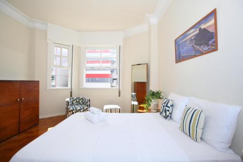 1 dormitorio blanco con 1 cama blanca grande y 2 ventanas en Unhotel - Apartamento de Temporada em Ipanema com 4 quartos, en Río de Janeiro