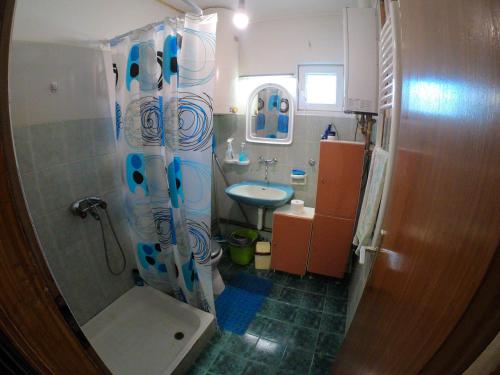 a bathroom with a shower curtain and a sink at sobe MAŠA in Subotica