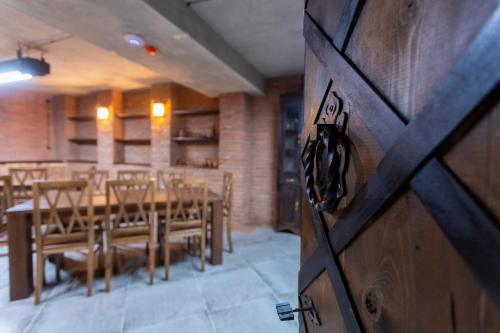 a wooden door in a room with a table and chairs at Hotel West Way in Kutaisi