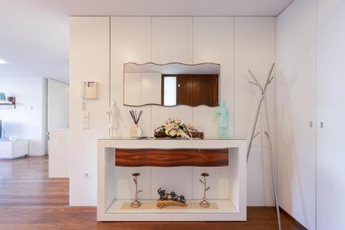 Cette chambre blanche dispose d'une coiffeuse avec un miroir. dans l'établissement Apartamento Qian Caves de Gaia, à Vila Nova de Gaia