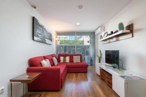 a living room with a red couch and a tv at Apartamento Qian Caves Gaia 2BR AC Free Parking in Vila Nova de Gaia