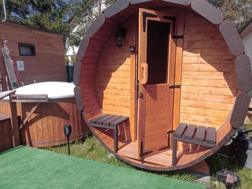 a large wooden dog house with two chairs in it at Domki i pokoje ,,Pod Palmami" w centrum in Okuninka