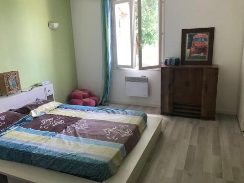 une chambre avec un grand lit et une fenêtre dans l'établissement Maison plein pied Drome Provençale, à La Baume-de-Transit