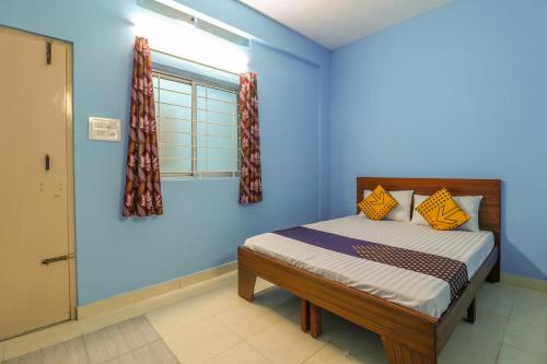 - une chambre avec un lit aux murs bleus et une fenêtre dans l'établissement SPOT ON 61234 Pradeep Stays, à Bangalore