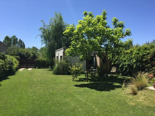 un patio con una casa y un árbol en Stunning modern apartment in gated community en Luján de Cuyo