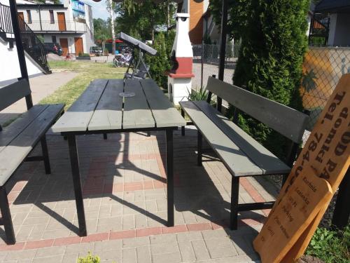 a picnic table and a bench and a telescope at Domki i pokoje ,,Pod Palmami" w centrum in Okuninka