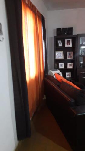 sala de estar con sofá y ventana en Departamento Matienzo en Maipú