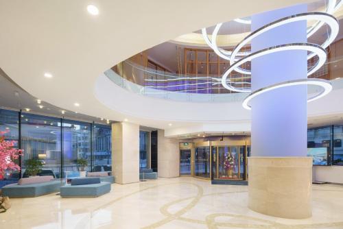 a lobby with a spiral staircase in a building at Holiday Inn Express City Centre Dalian by IHG in Dalian