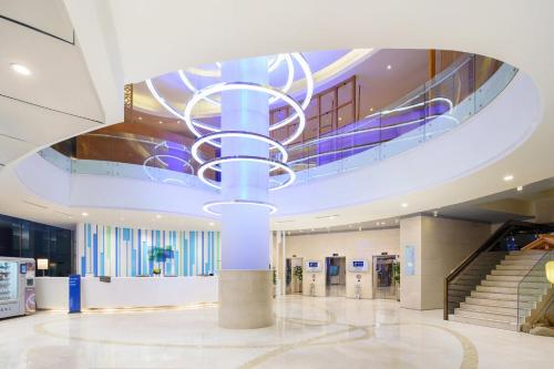 a lobby with a large chandelier in a building at Holiday Inn Express City Centre Dalian by IHG in Dalian