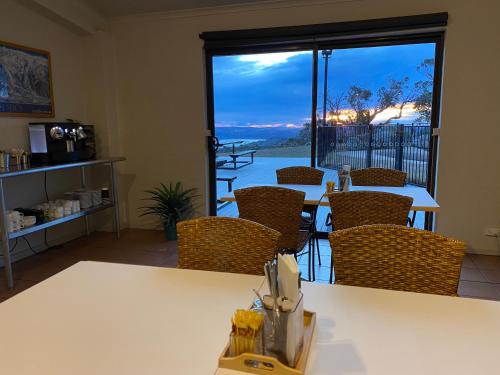 a living room with a table and chairs and a window at Altitude 1260 in Jindabyne