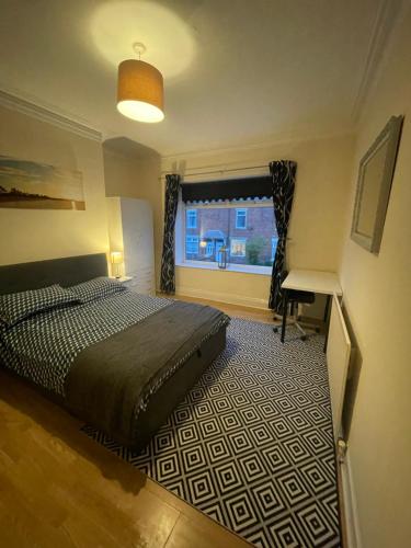a bedroom with a bed and a desk and a window at The Beach Loft in Newbiggin-by-the-Sea
