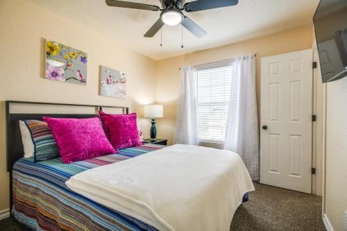 a bedroom with a bed with pink pillows and a ceiling fan at San Antonio Townhome about 2 Mi to Aquarium! in San Antonio