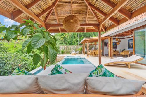 an outdoor living room with a couch and a swimming pool at Hotel Spa La Colina in Pereira