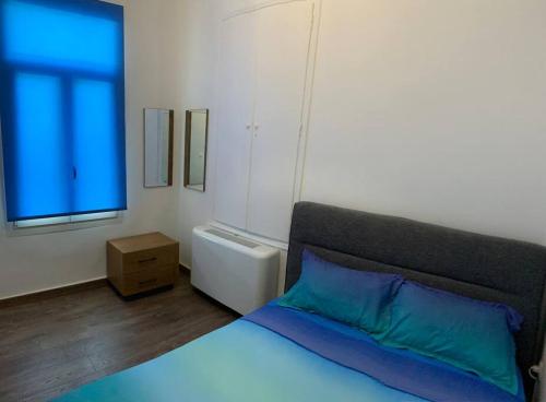 a bedroom with a bed with a blue pillow and a window at Blue Flag Award Winning Beach: Home 2 in Vrontados