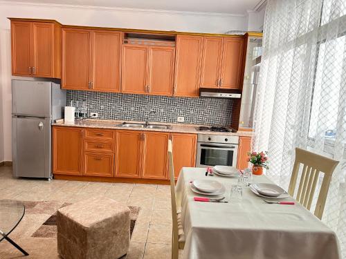 una cocina con armarios de madera y una mesa con platos. en Tirana AS Apartment 1, en Tirana