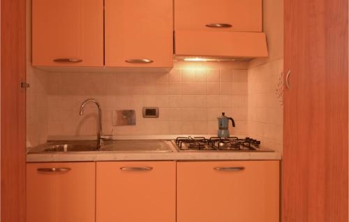 cocina con armarios de color naranja y fregadero en Stunning Apartment In Diano Marina With Wifi, en Diano Marina