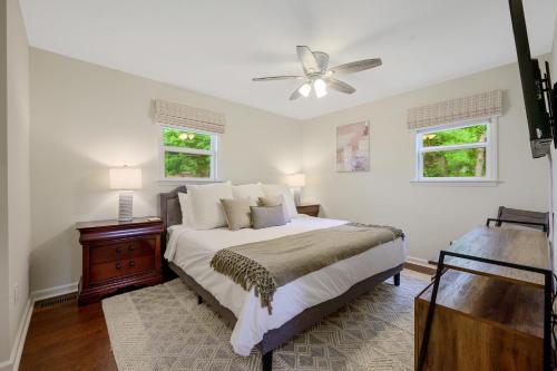 een witte slaapkamer met een bed en een plafondventilator bij Short Walk to Downtown Historic Hillsborough UnitB in Hillsborough