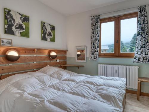 une chambre avec un lit blanc et une fenêtre dans l'établissement Appartement cosy 2 pièces, terrasse, parking, à 5 min des pistes - Megeve Jaillet - FR-1-453-225, à Megève