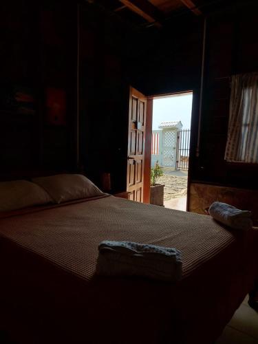 a bedroom with a bed in a room with an open door at Sunset Bay B&B in Corn Island