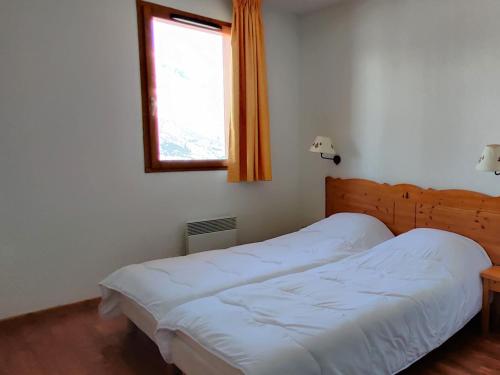 a bedroom with a white bed with a window at Appartement Le Dévoluy, 3 pièces, 6 personnes - FR-1-504-473 in Superdevoluy