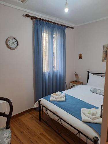 a bedroom with a bed and a window with blue curtains at Mary's Art House in the center of Old town in Corfu Town