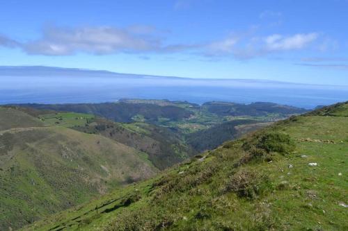 a view from the top of a hill with the ocean in the background at Hotel Restaurante el Fornon in Novellana