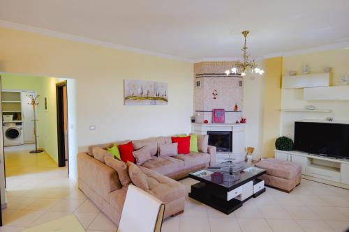 Una sala de estar con un sofá y una chimenea. en Vila Landi Ksamil, en Ksamil