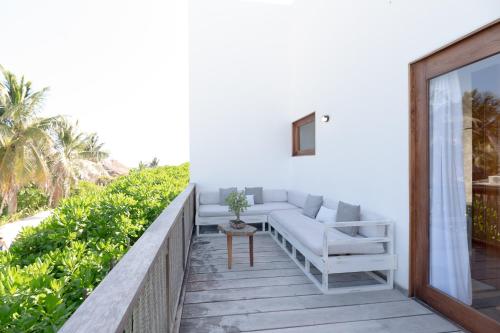 a balcony with a couch and a table at Kai Tulum in Tulum
