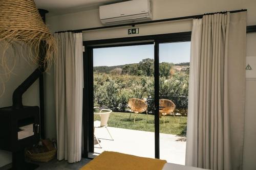 Casa da Aldeia - Small House -Terra - Peniche - Baleal في Casais Brancos: غرفة نوم مع باب زجاجي منزلق إلى الفناء