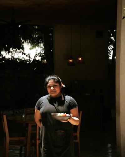 a woman is holding a plate of food at Casona los Cedros in Espita