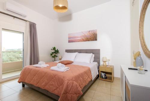 ヘルソニソスにあるΝΜΒ Anissaras Coastal Getawayのベッドとタオル2枚のある寝室