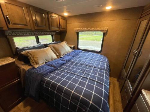 a bedroom with a blue bed in an rv at Quiet Country Rimrock Retreat RV in Hayden