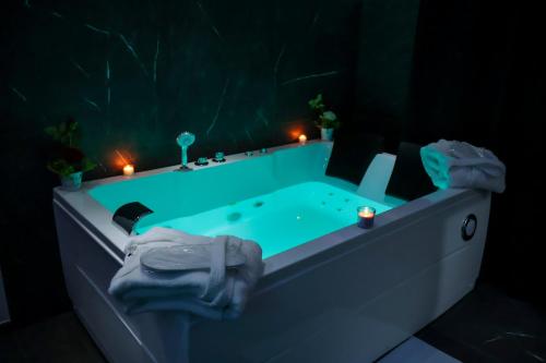 a blue bath tub with candles in a dark room at Wellness Home Catania in Catania