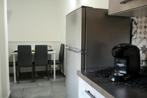 a kitchen with a refrigerator and a table with chairs at Wellness Home Catania in Catania