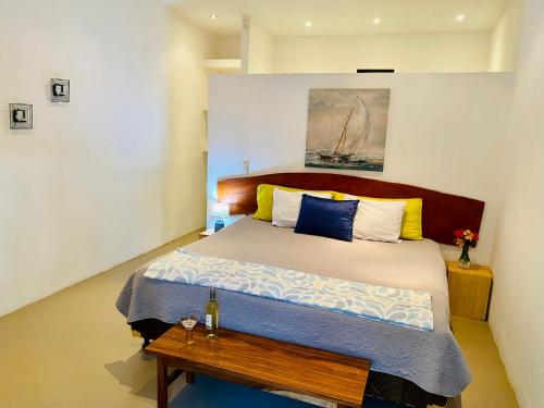 een slaapkamer met een groot bed met een houten hoofdeinde bij Antema Lodge Secteur Tamarindo, piscine, yoga, gym, jungle et paix in Tamarindo