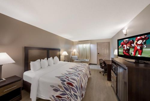 a hotel room with a large bed and a flat screen tv at Red Roof Inn Jasper in Jasper