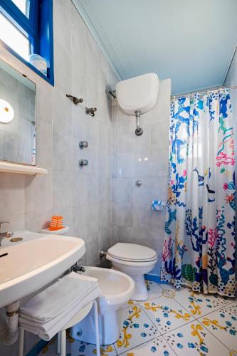 a bathroom with a toilet and a shower curtain at Villaggio Residence Nettuno in Massa Lubrense