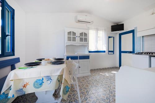 a blue and white kitchen with a table in a room at Villaggio Residence Nettuno in Massa Lubrense