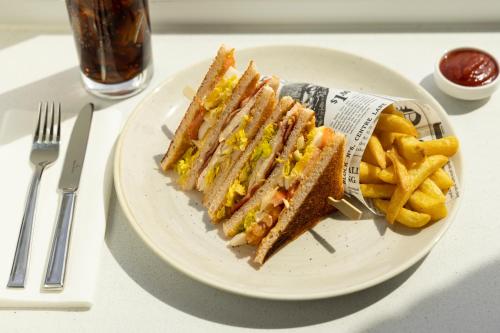 a plate with a sandwich and french fries on a table at Holiday Inn - Eindhoven Airport by IHG in Eindhoven