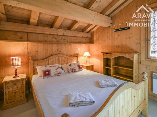 a bedroom with a bed in a wooden cabin at Appartement Le Grand-Bornand, 4 pièces, 6 personnes - FR-1-391-98 in Le Grand-Bornand