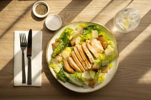 a plate of food with chicken and salad on a table at Holiday Inn - Eindhoven Airport by IHG in Eindhoven