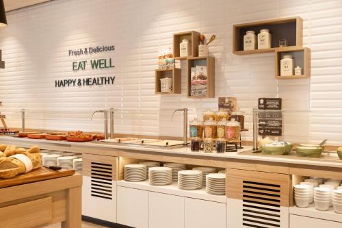 a kitchen with a counter with food on it at Holiday Inn - Eindhoven Airport by IHG in Eindhoven