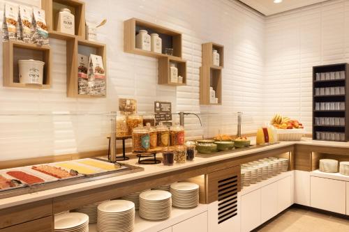 a kitchen with a counter with plates and food at Holiday Inn - Eindhoven Airport by IHG in Eindhoven