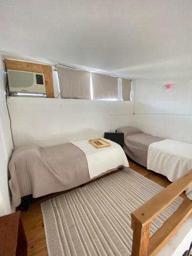 Habitación pequeña con 2 camas y ventana en Temporario Roca en Corrientes