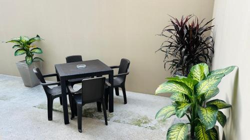 a black table and chairs in a room with plants at Large 2-Bedroom Apartment, close to the American Consulate in Guayaquil