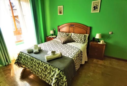 1 dormitorio verde con 1 cama con 2 toallas en Piso amplio y luminoso, La Pomar, en Langreo