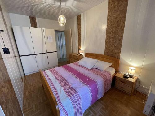 une chambre avec un grand lit et deux tables de nuit dans l'établissement Appartement T2 avec balcon, parking privé et proche plage, Saint-Hilaire-de-Riez - FR-1-224C-118, à Saint-Hilaire-de-Riez