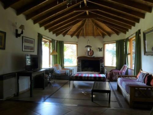 a living room with a couch and a fireplace at Casa en el bosque a metros del lago Nahuel Huapi in San Carlos de Bariloche